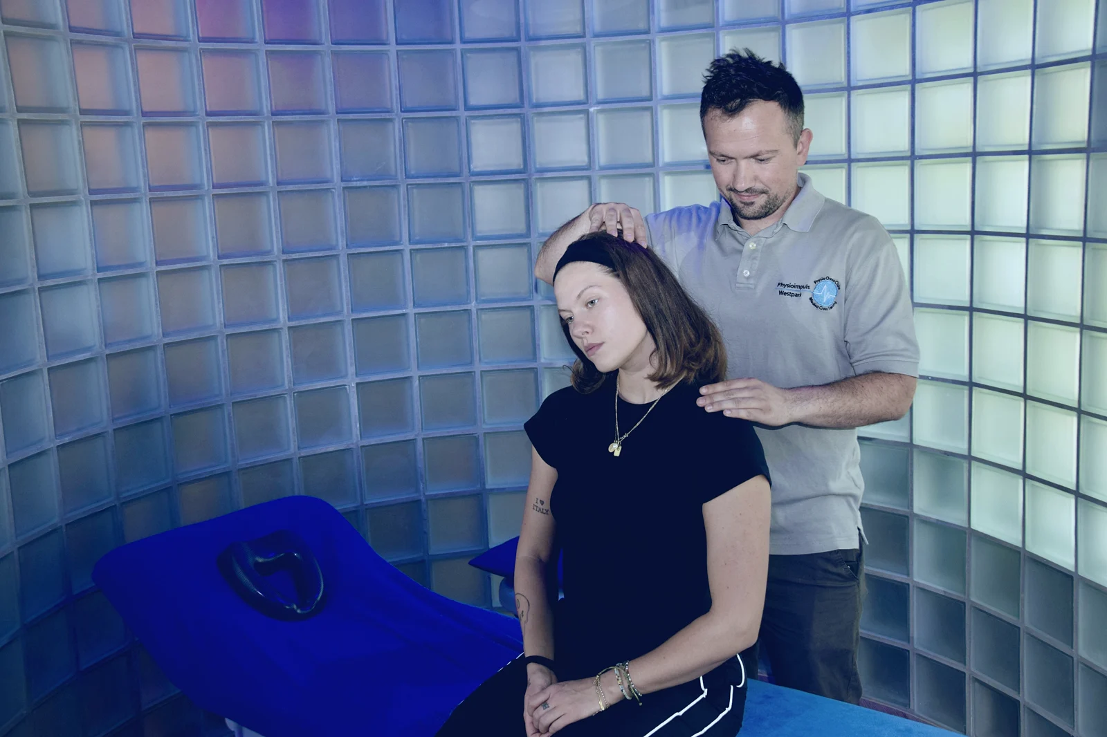 Therapeut von Physioimpuls Westpark behandelt die Halswirbelsäule einer Patientin