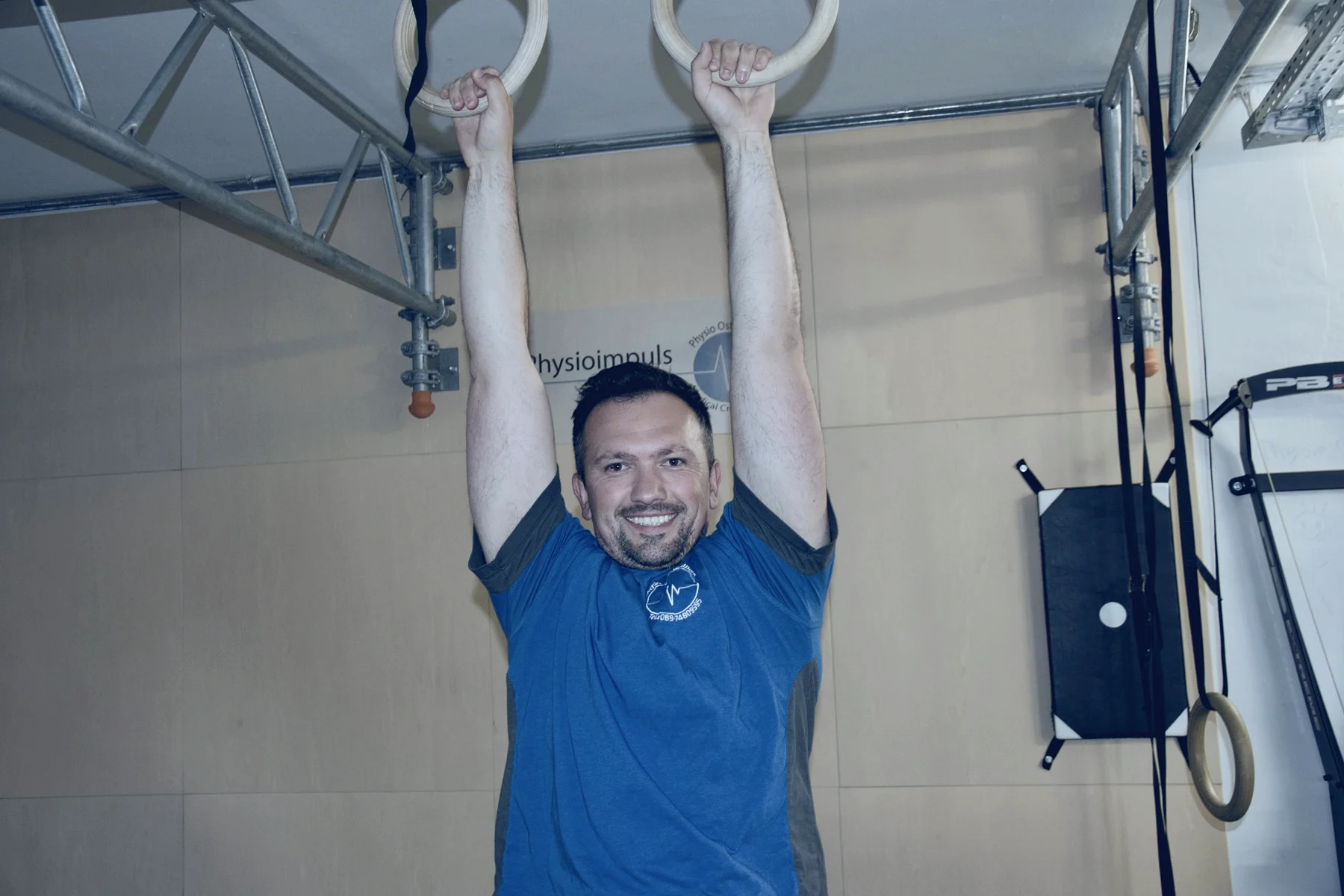 Therapeut an den Turnringen im Trainings- und Rehabilitationsbereich von Physioimpuls Westpark